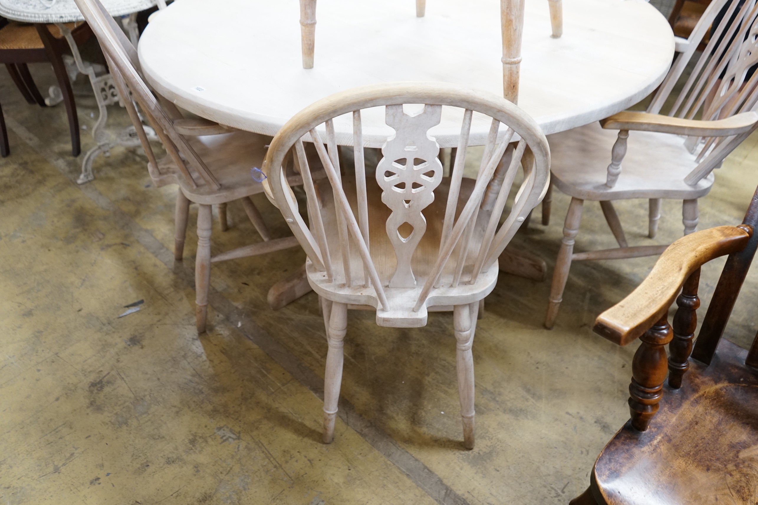 A set of eight Victorian style limed beech Windsor wheelback elbow chairs